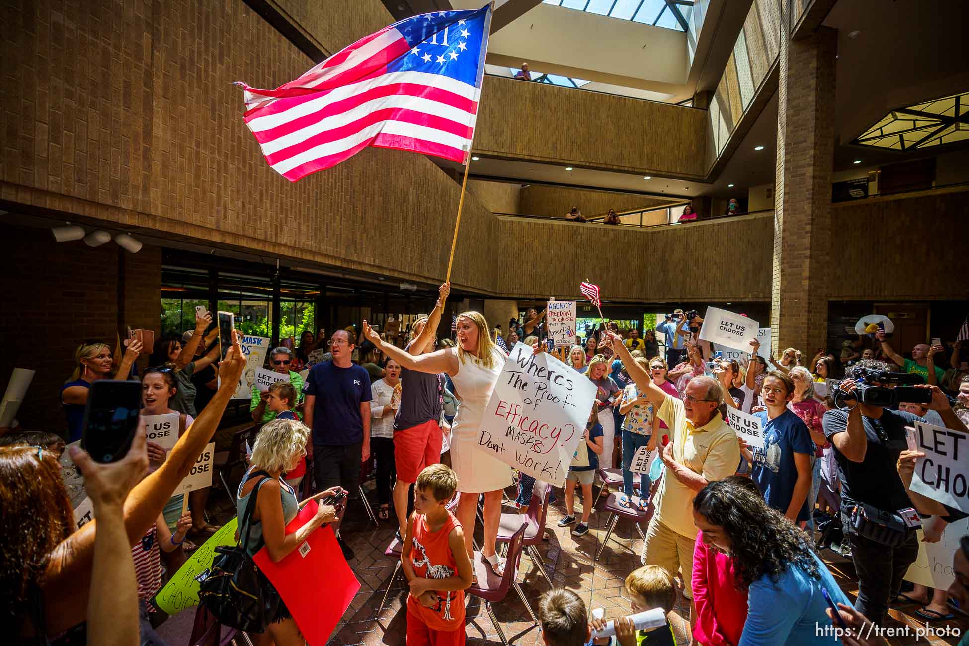 (Trent Nelson  |  The Salt Lake Tribune) People sing the National Anthem under a Three Percenter flag after the Salt Lake County Council voted down Dr. Angela Dunn's mask ordinance for K-6 students, on Thursday, Aug. 12, 2021.