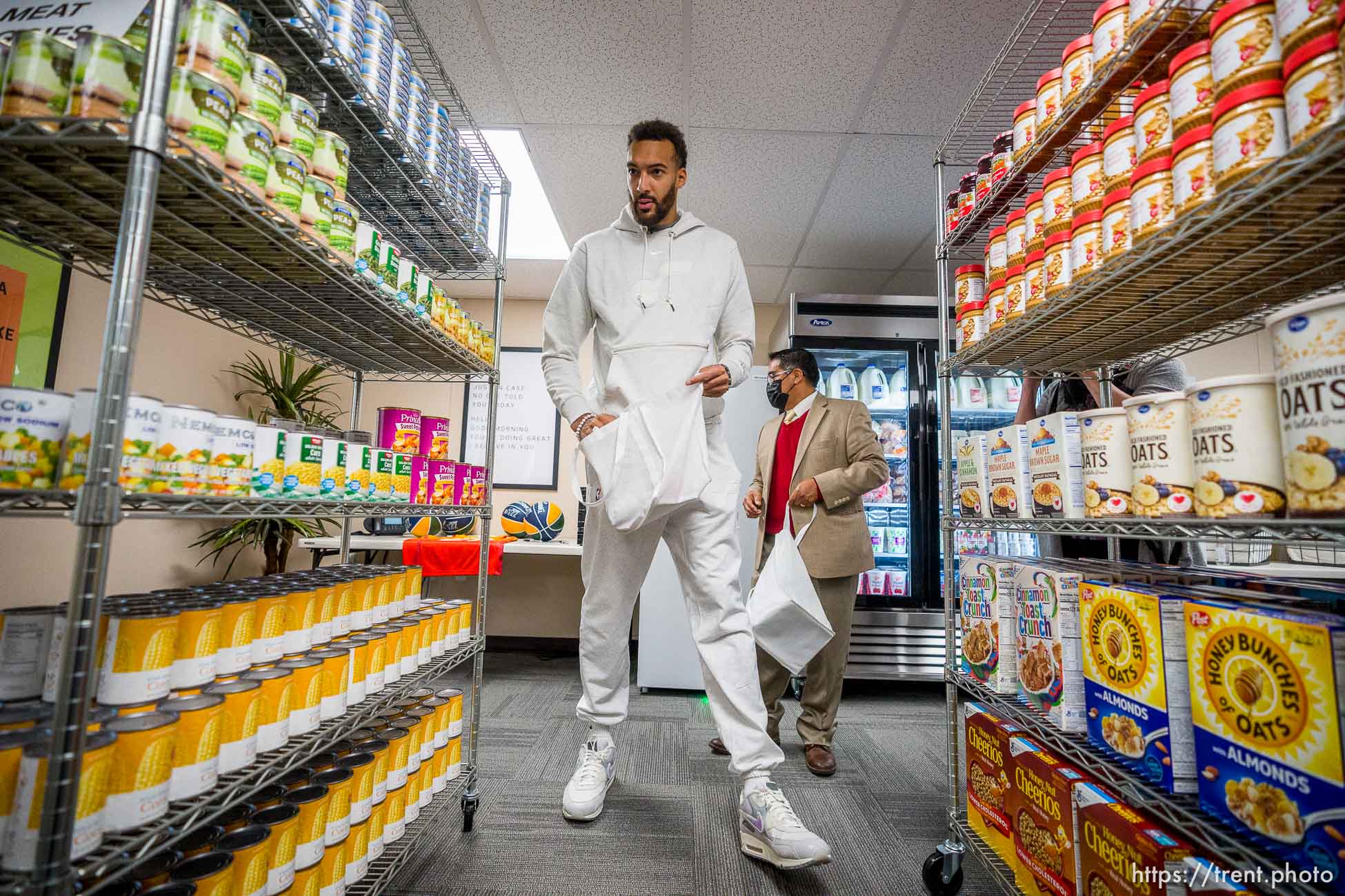 (Trent Nelson  |  The Salt Lake Tribune) Utah Jazz center Rudy Gobert visits Northwest Middle School to see the new food pantry, in Salt Lake City on Thursday, Oct. 14, 2021. Rudy's Kids Foundation, Smith's Food and the Salt Lake Education Foundation combined efforts to open the food pantry. At rear is James Yapias of the Salt Lake Education Foundation.