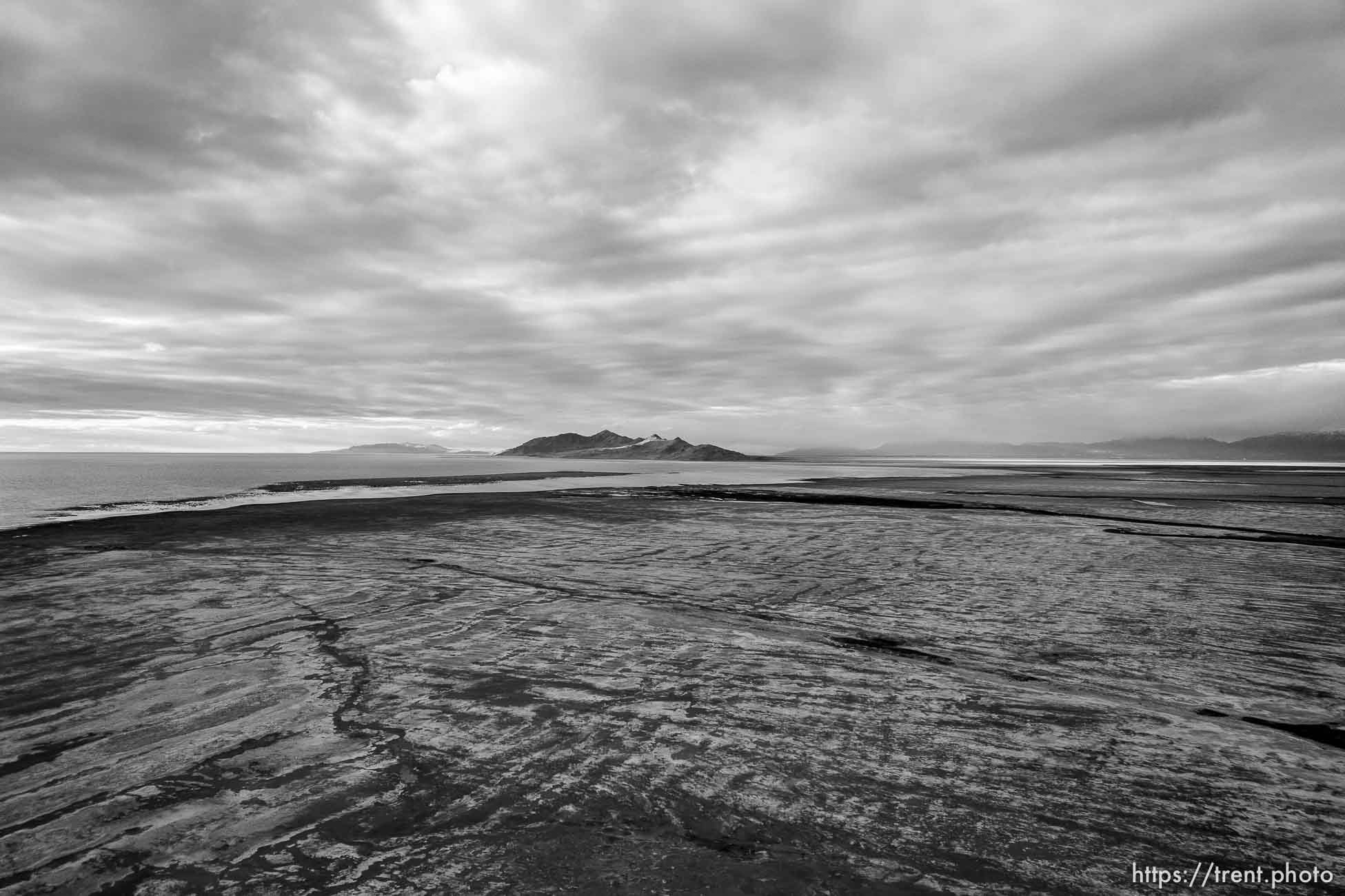 (Trent Nelson  |   The Salt Lake Tribune) The setting sun lights Antelope Island in the distance from the receding shore of the Great Salt Lake on Thursday, Oct. 14, 2021.| The Salt Lake Tribune)