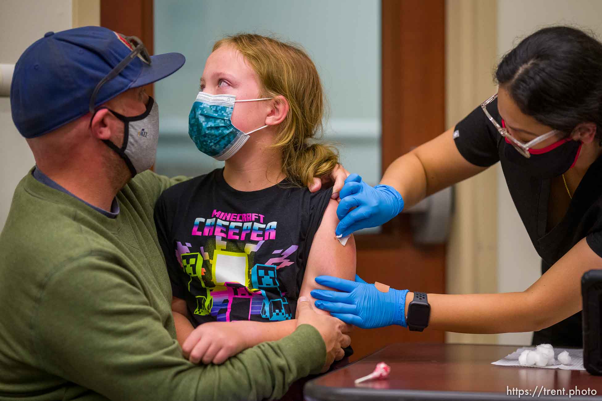 (Trent Nelson  |  The Salt Lake Tribune) Jason Miller holds his daughter, Nina, as she is vaccinated against COVID-19 by Tenzin Drongsar at South Main Public Health Center in South Salt Lake on Wednesday, Nov. 3, 2021.