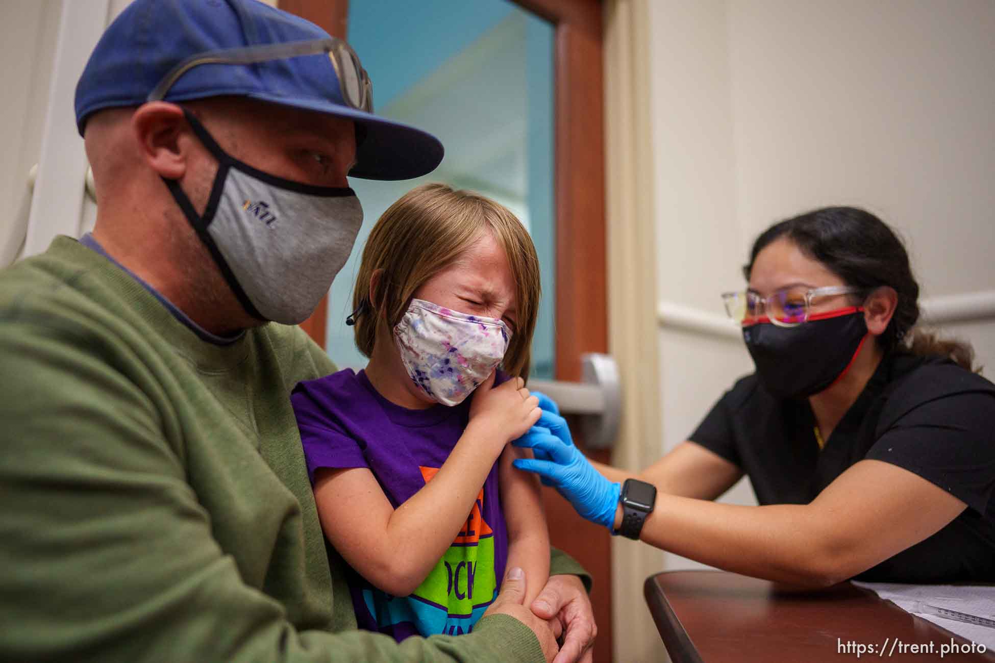 (Trent Nelson  |  The Salt Lake Tribune) Jason Miller holds his daughter, Teagan, as she is vaccinated against COVID-19 by Tenzin Drongsar at South Main Public Health Center in South Salt Lake on Wednesday, Nov. 3, 2021.