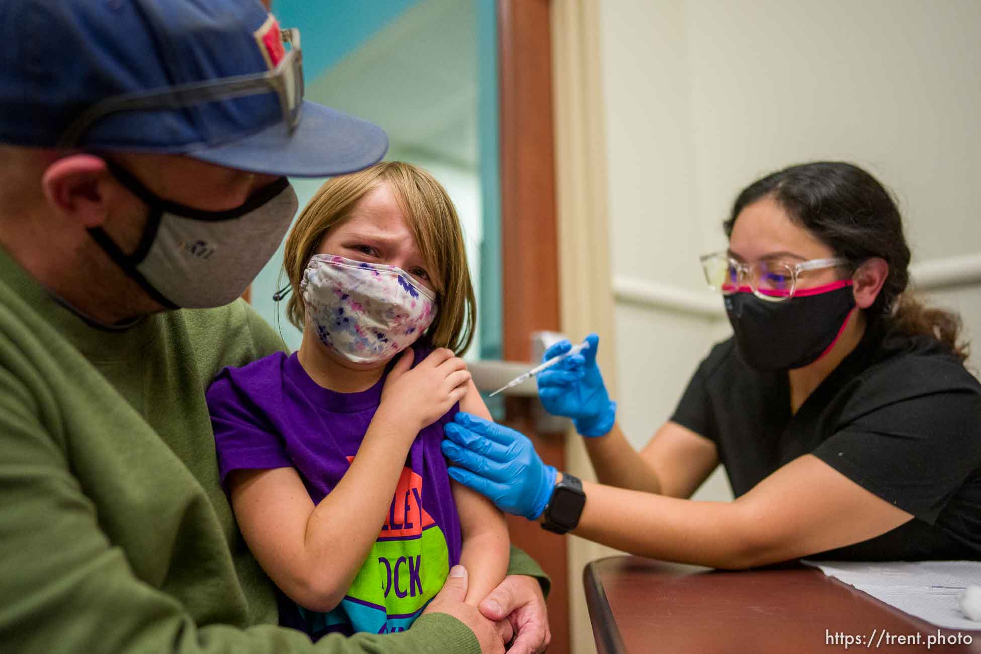 (Trent Nelson  |  The Salt Lake Tribune) Jason Miller holds his daughter, Teagan, as she is vaccinated against COVID-19 by Tenzin Drongsar at South Main Public Health Center in South Salt Lake on Wednesday, Nov. 3, 2021.