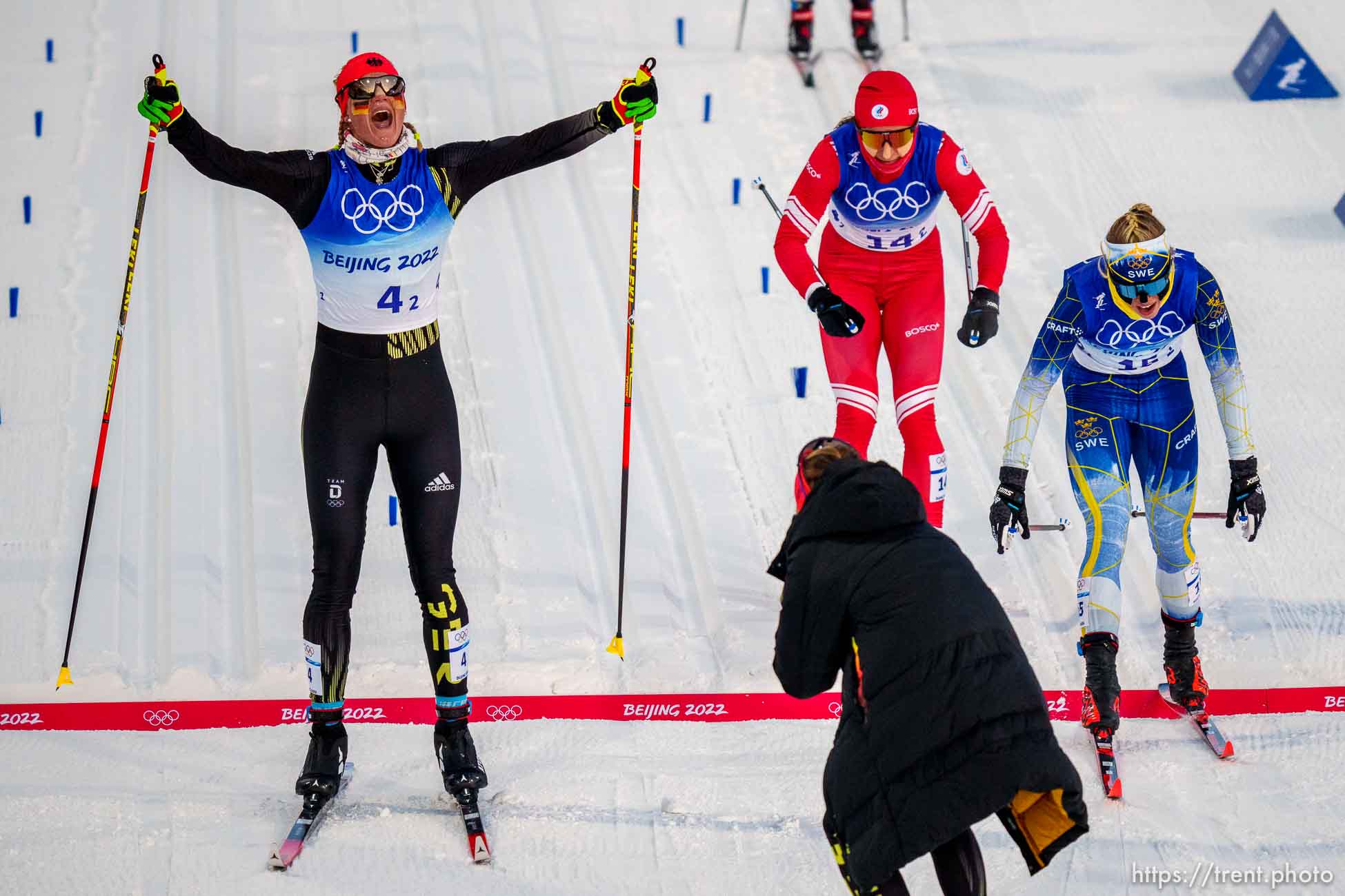 (Trent Nelson  |  The Salt Lake Tribune) Victoria Carl (Germany) crosses the finish line, winning the gold medal in the women's team sprint classic, cross-country skiing at the 2022 Beijing Winter Olympics in Zhangjiakou on Wednesday, Feb. 16, 2022. At far right is Jonna Sundling (Sweden) and at center is Natalia Nepryaeva (ROC).