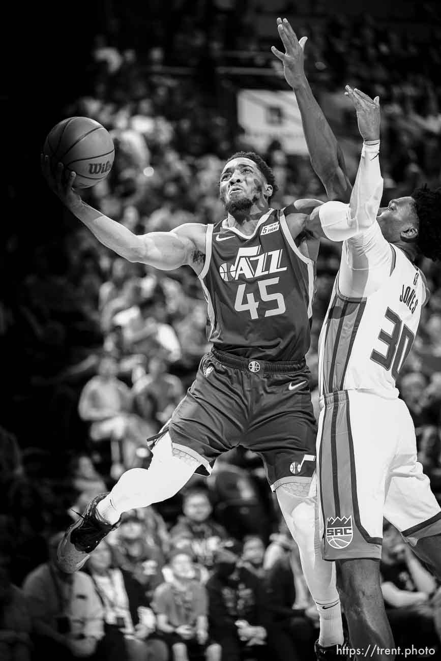 (Trent Nelson  |  The Salt Lake Tribune) Utah Jazz guard Donovan Mitchell (45) drives, defended by Sacramento Kings center Damian Jones (30) as the Utah Jazz host the Sacramento Kings, NBA basketball in Salt Lake City on Saturday, March 12, 2022.