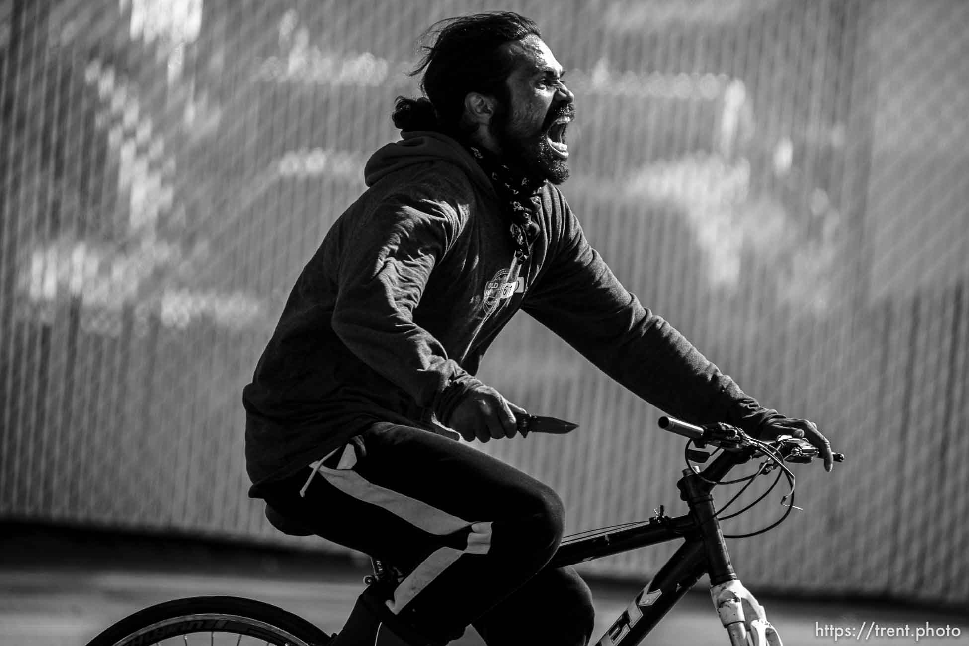 guy riding bike down 1700 south with a knife on Thursday, March 17, 2022.