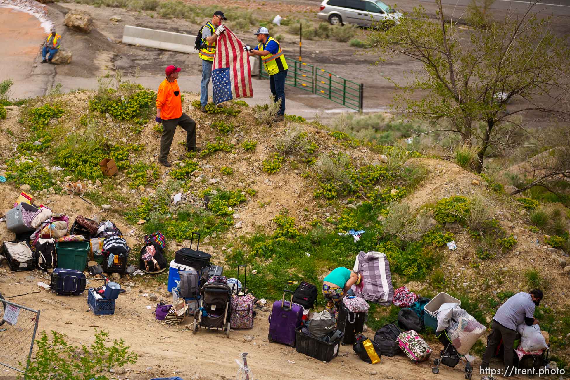 (Trent Nelson  |  The Salt Lake Tribune) A flag is folded by workers as people in camps pack up their belongings in the foothills north of Salt Lake City on Wednesday, April 27, 2022.