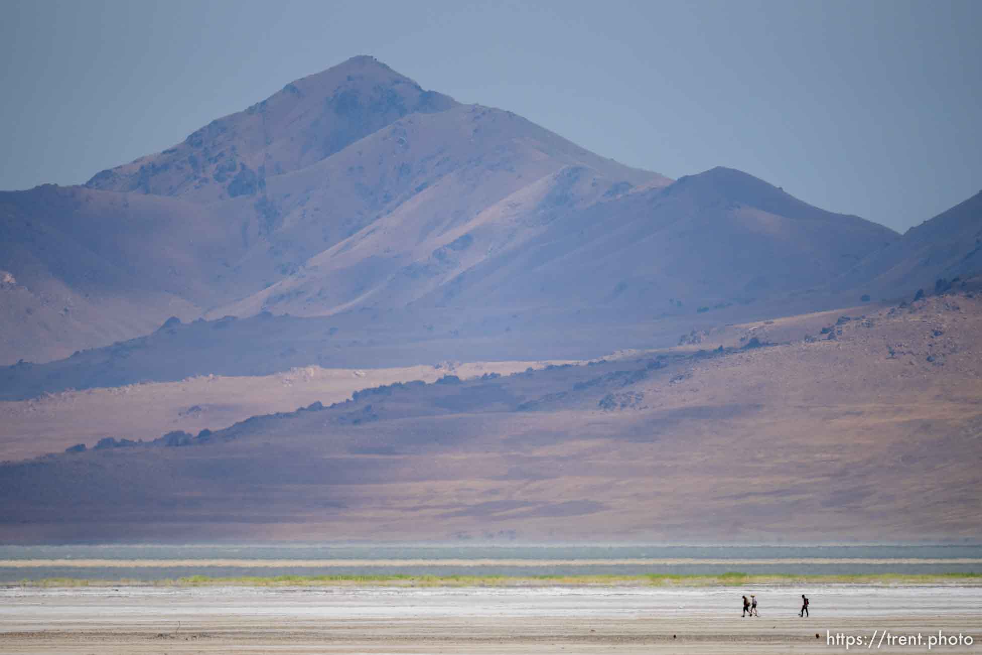 (Trent Nelson  |  The Salt Lake Tribune) Antelope Island looms over hikers at the Great Salt Lake on Saturday, June 18, 2022.