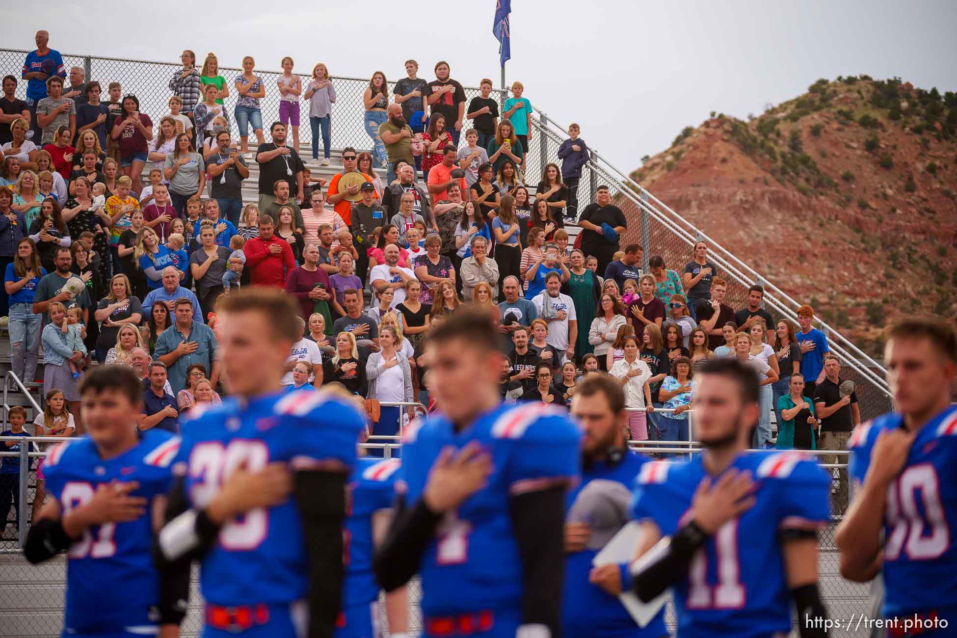 (Trent Nelson  |  The Salt Lake Tribune) Water Canyon High School football fans stand for the National Anthem in Hildale on Friday, Aug. 12, 2022.