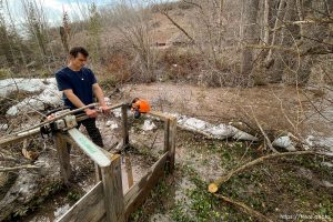 (Trent Nelson  |  The Salt Lake Tribune) As water rushes through his yard, Jordan Hess waits for another load of sandbags to arrive, in Emigration Canyon on Wednesday, April 12, 2023.