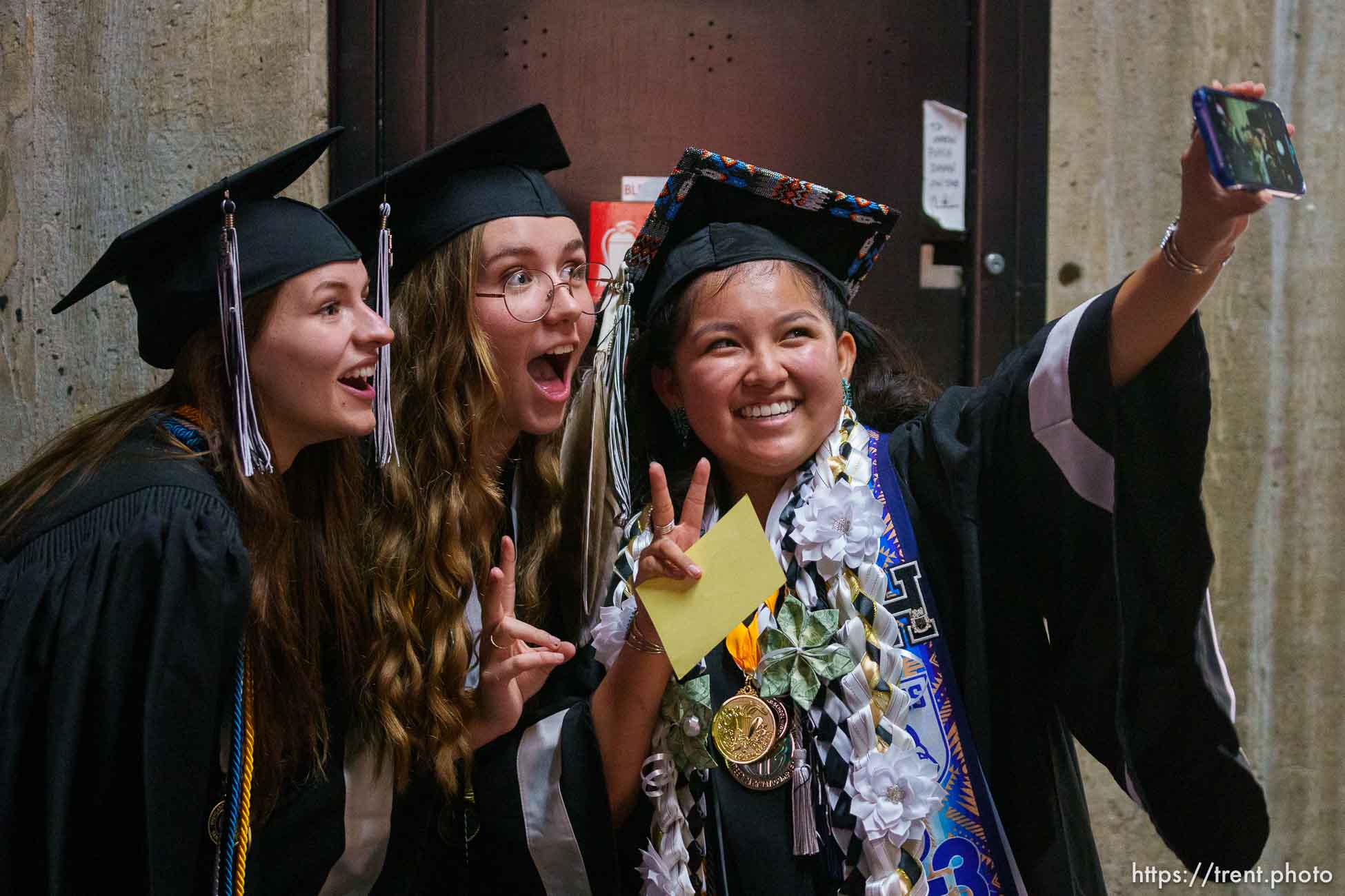 (Trent Nelson  |  The Salt Lake Tribune) Kayden Denny takes a selfie with Annie Pasmann and Eleanor Scoville at Highland High School's graduation in Salt Lake City on Friday, June 9, 2023.