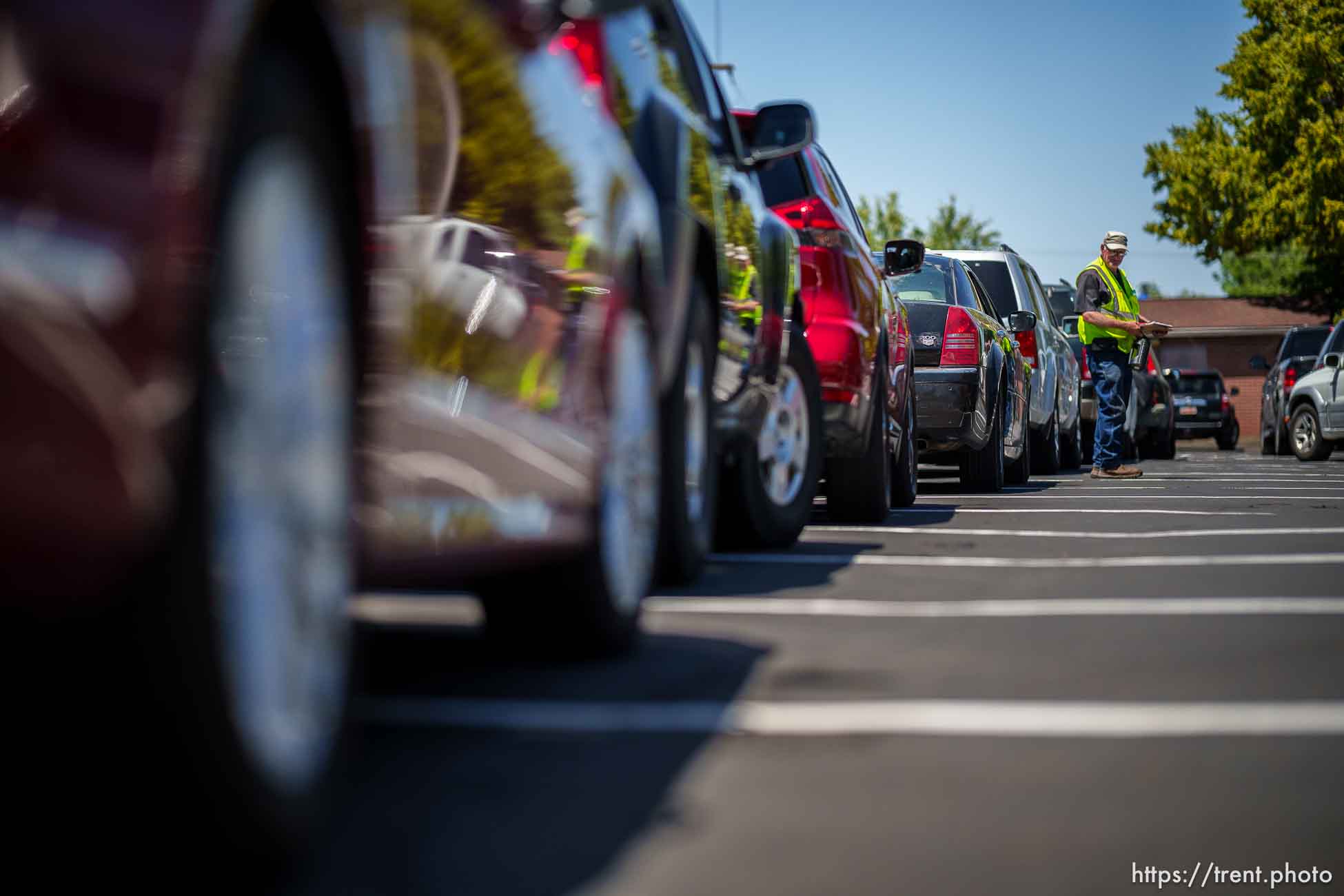 (Trent Nelson  |  The Salt Lake Tribune) Volunteer Steven Hurst walks a long line of cars at a mobile food pantry sponsored by Utah Food Bank in Taylorsville on Monday, June 26, 2023