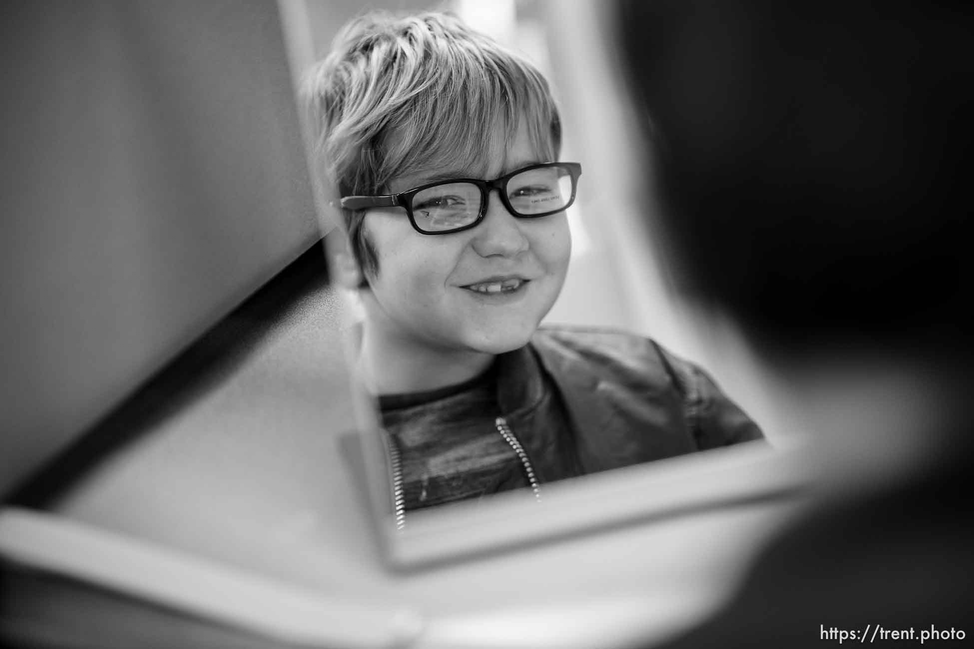 (Trent Nelson  |  The Salt Lake Tribune) Second grader Emmett Knight tries on frames at the vision clinic in Salt Lake City's Parkview Elementary on Friday, Dec. 1, 2023.