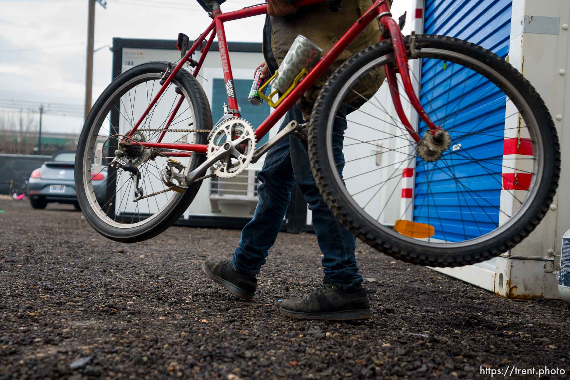 (Trent Nelson  |  The Salt Lake Tribune) A resident pulls his bike from a storage pod at Salt Lake City’s first legal homeless camp on Tuesday, Dec. 19, 2023.