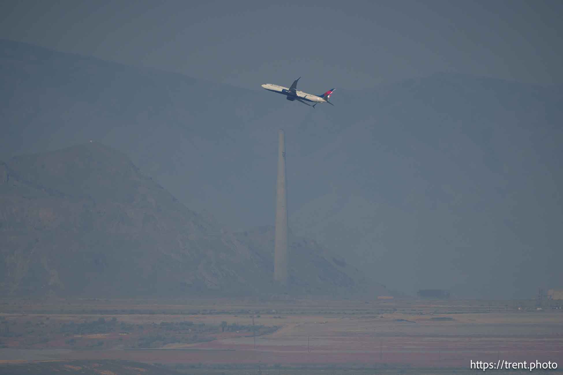 (Trent Nelson  |  The Salt Lake Tribune) A passenger jet takes off in a dusty, hazy Salt Lake Valley on Wednesday, July 10, 2024.