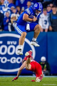 (Trent Nelson  |  The Salt Lake Tribune) BYU Cougars quarterback Bear Bachmeier (47) leaps over Utah Utes safety Jackson Bennee (23) as BYU hosts Utah, NCAA football at LaVell Edwards Stadium in Provo on Saturday, Oct. 18, 2025.